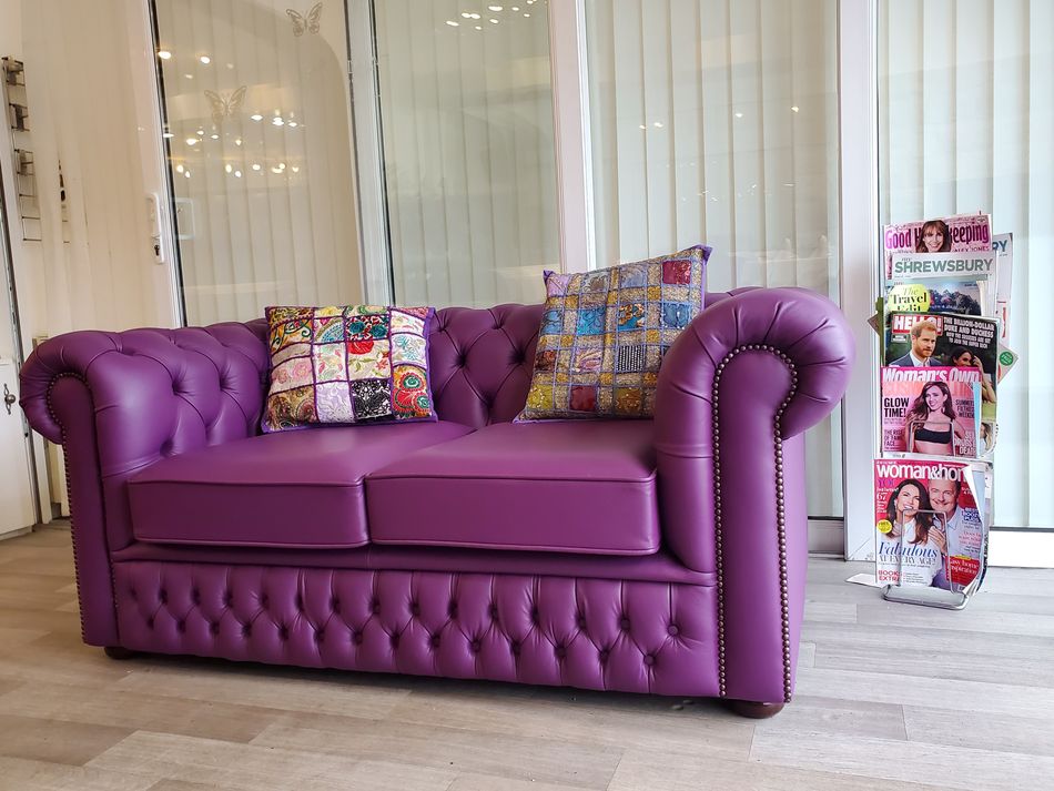 Welcoming purple sofa in Rainbow Connection salon waiting area